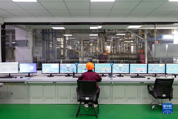 技术工程师在生产线边的中央控制室内关注5G通信下智能化生产状况